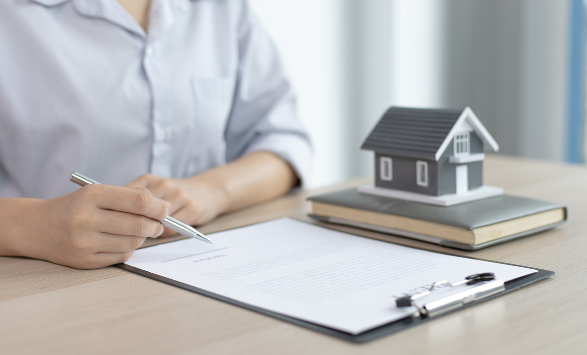 Woman Signing a Real Estate Document        